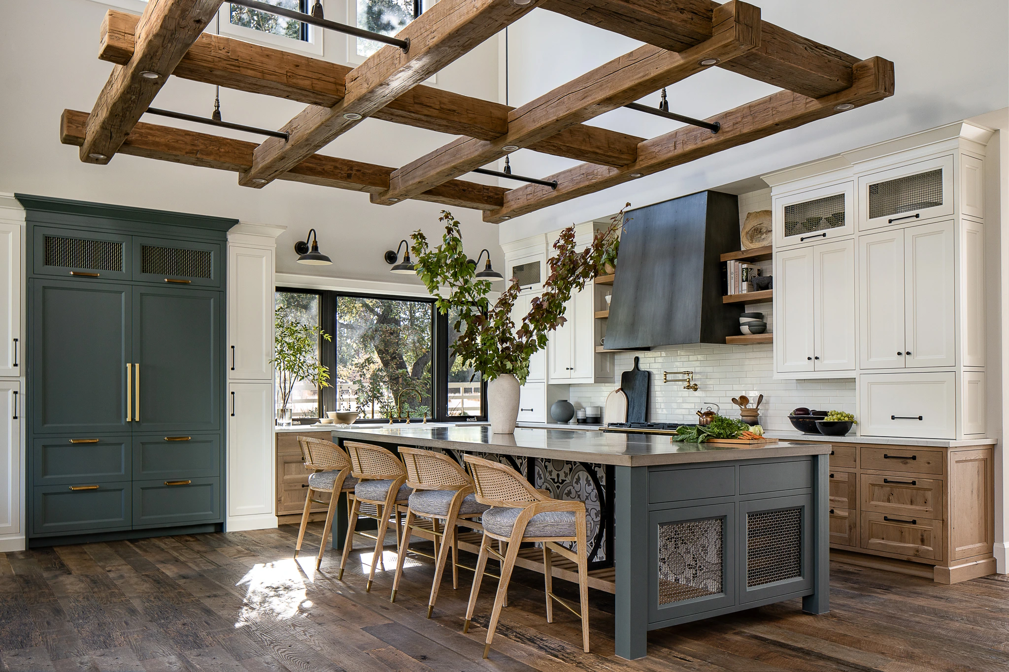 Open kitchen with dark green island and cabinets under a wood ceiling